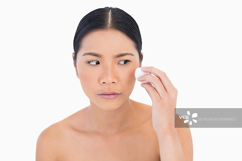 用化妆棉擦脸的好奇美女模特图片素材