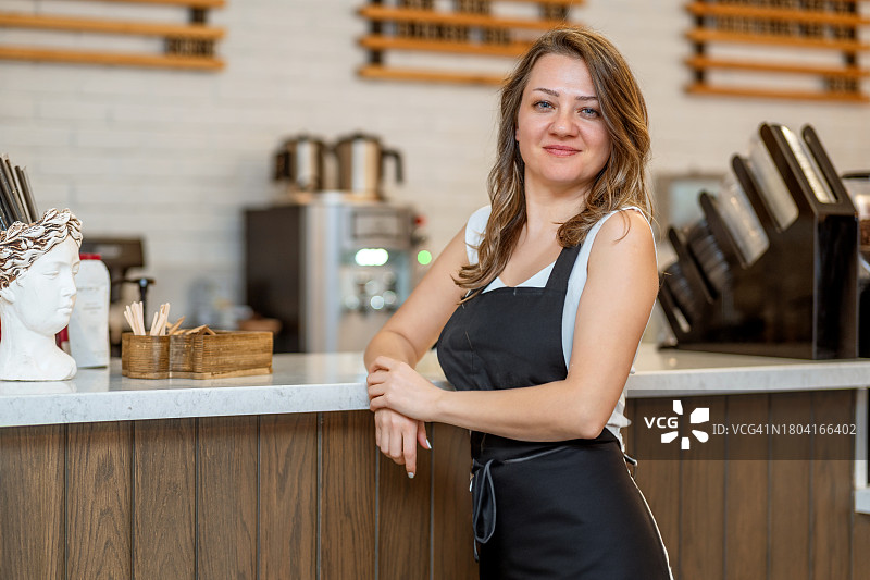 咖啡馆女店主在店前自豪地摆姿势图片素材