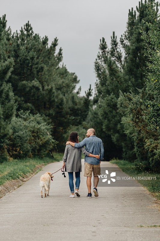 情侣遛狗时拥抱图片素材