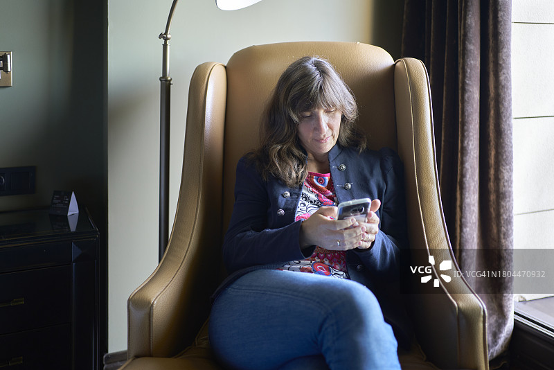 在卧室沙发上用手机的女人图片素材