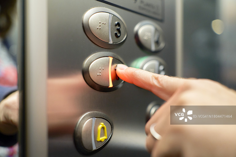 酒店内游客按下电梯按钮的特写镜头图片素材