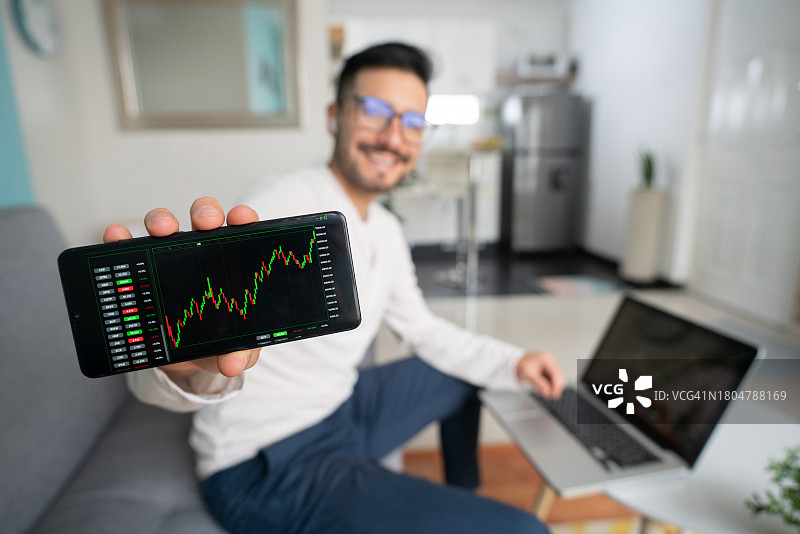 快乐的男人看着他在股市的投资图片素材