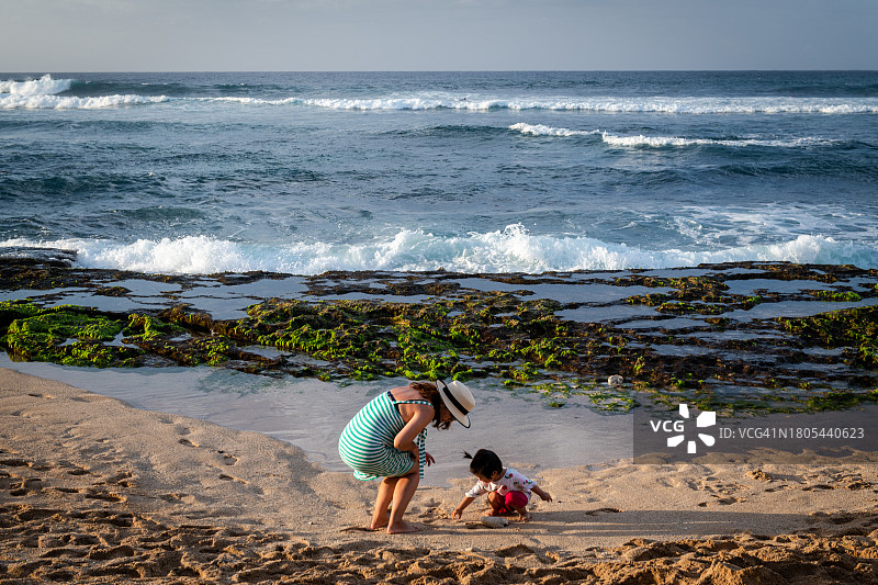 幼儿和母亲在毛伊岛霍欧基帕海滩玩耍图片素材