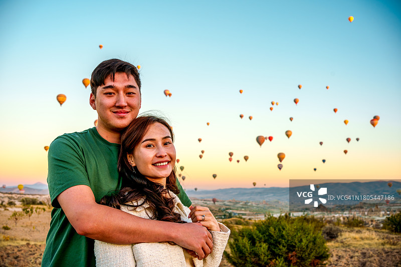 游客度假时欣赏热气球在空中飞行图片素材
