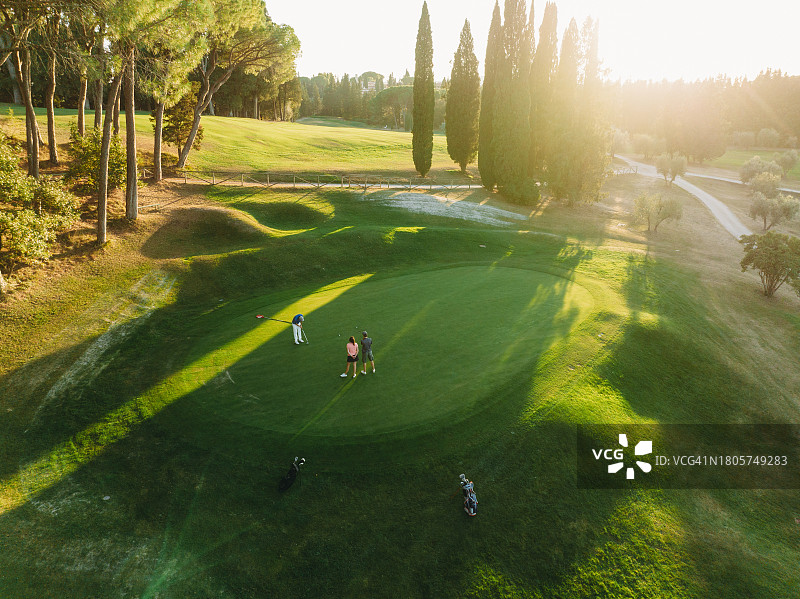 三人一起打高尔夫的航拍图片素材