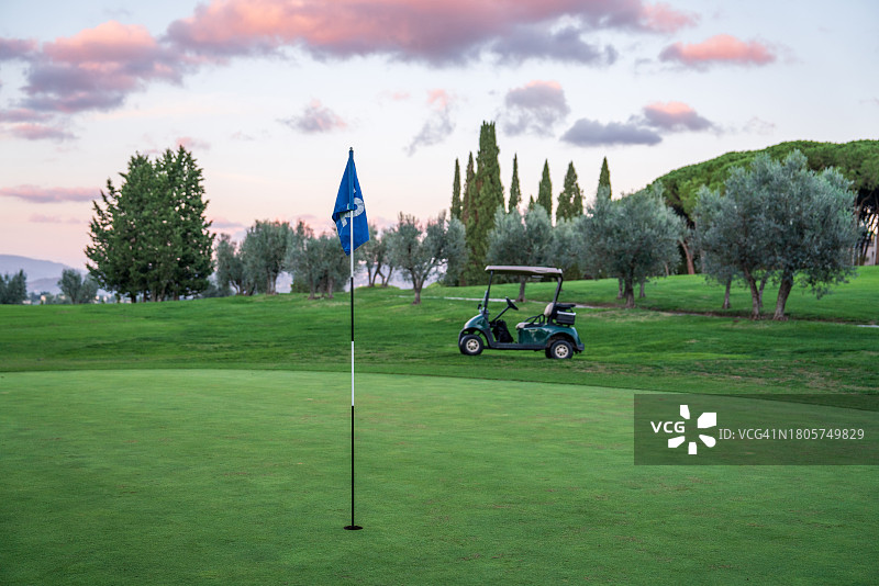 日落时分带有旗帜的高尔夫球果岭图片素材