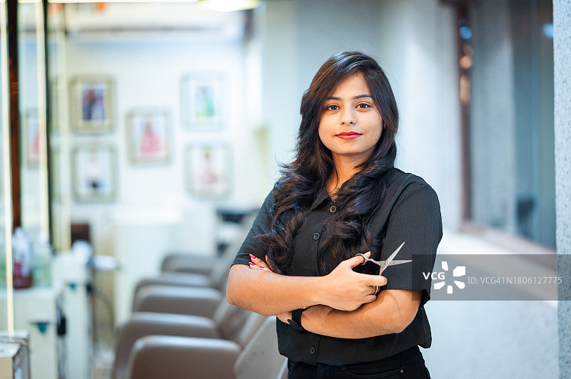 理发店里拿着剪刀的女理发师肖像图片素材