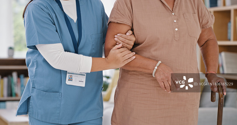 使用手杖在家的女性：护士，理疗师或护理人员在客厅提供康复支持图片素材