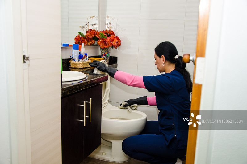女佣清洁公寓浴室的马桶图片素材