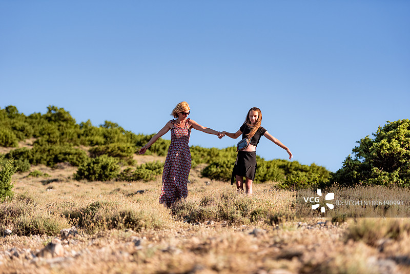 母亲和十几岁的女儿在地中海山丘欣赏美景图片素材