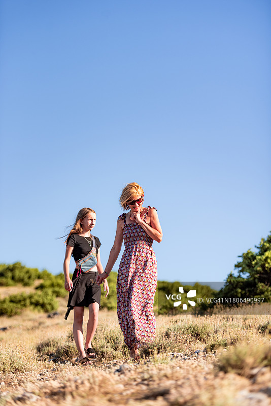 母亲和十几岁的女儿在地中海山丘欣赏美景图片素材