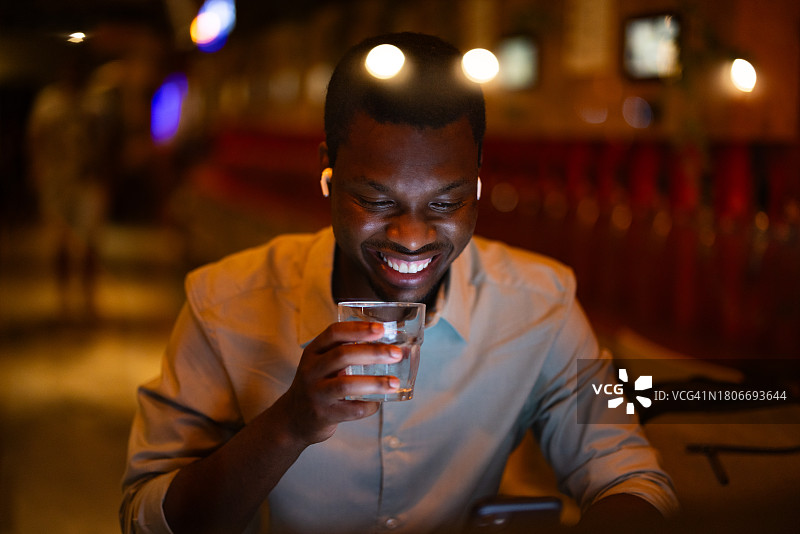 笑容满面的商务男士在餐厅喝水并参加在线会议图片素材