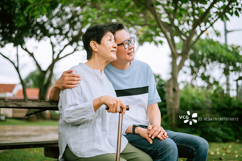 中国亚洲老妇人在花园里和儿子说话图片素材