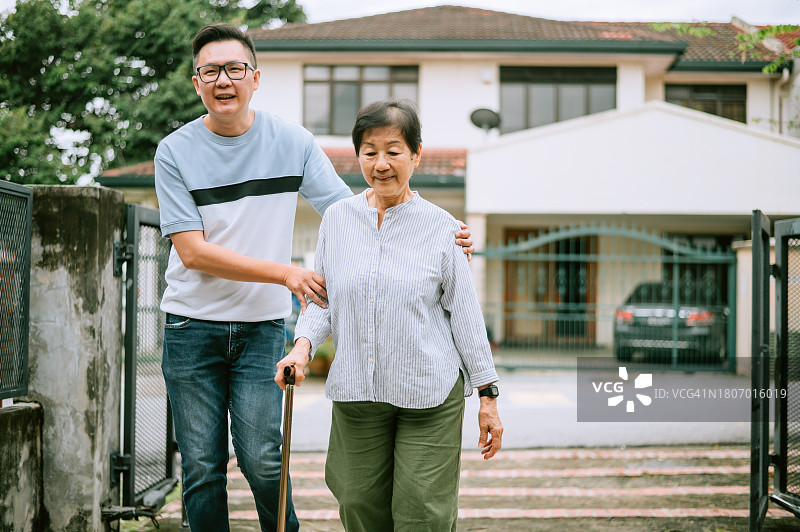 一位亚洲老妇带着儿子回家图片素材