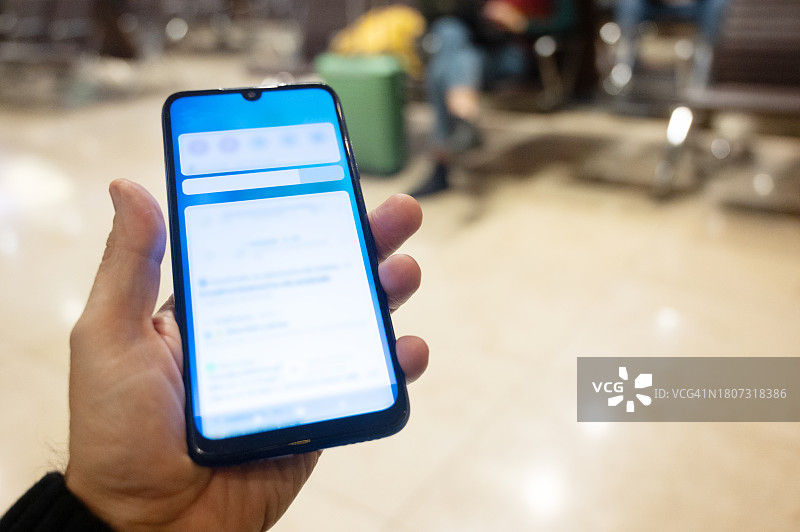 在机场休息室等待航班时看手机的人图片素材