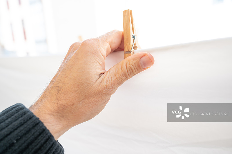 男人在阳台上晾床单图片素材