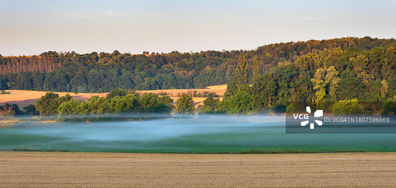 德国萨克森-安哈尔特州翁斯特鲁特河谷的田野、森林和晨雾全景图片素材