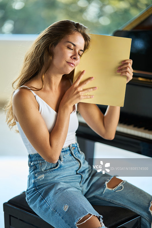 梦幻般的年轻女音乐家拿着音乐笔记本图片素材