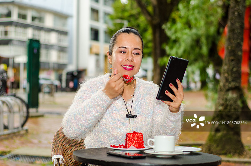 在咖啡店吃蛋糕并使用平板电脑的女人 портрет图片素材