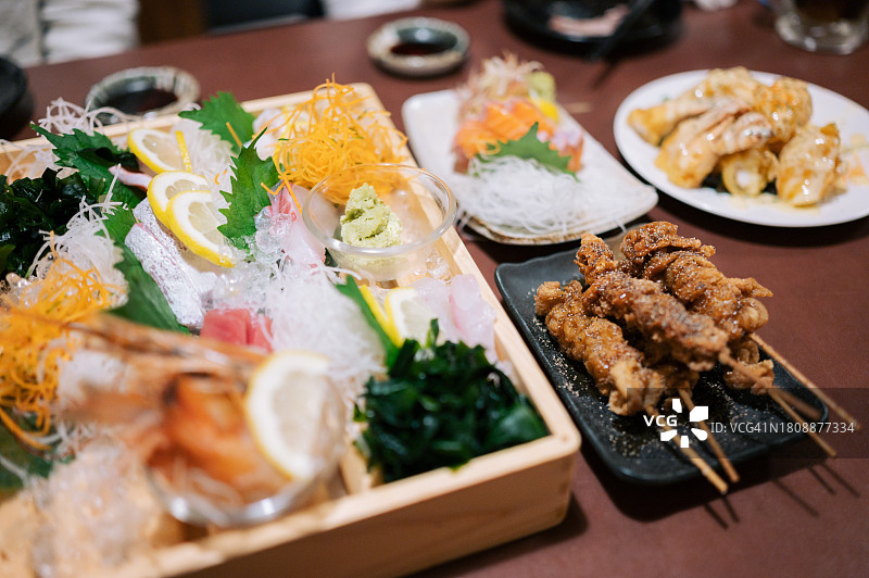 朋友们在日本当地餐厅享用生鱼片和日式料理图片素材