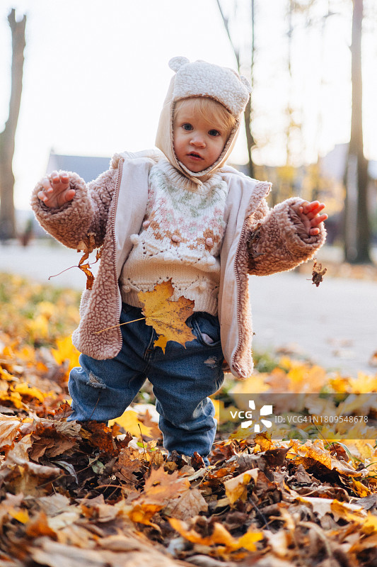 秋日公园里穿着暖和的可爱女婴图片素材