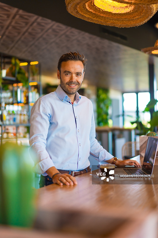 在自助餐厅工作的一位成功的休闲男商人肖像图片素材