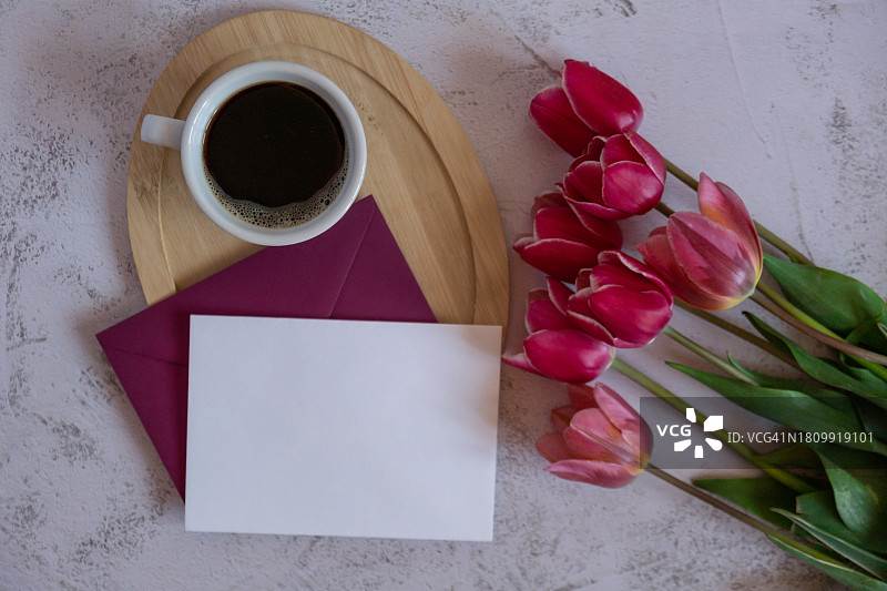 桌上咖啡杯和鲜花旁边的空白纸张俯视图图片素材