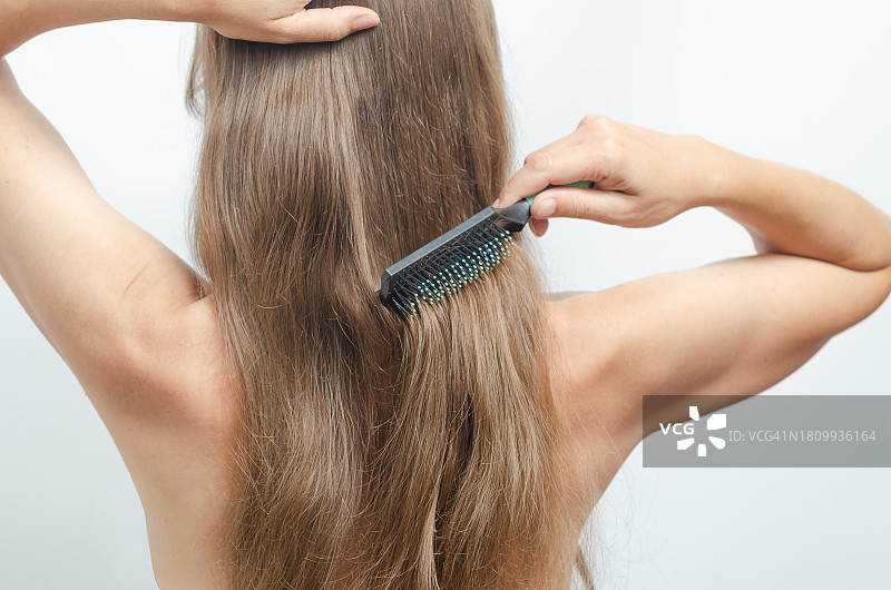 白色背景下梳头的女人特写图片素材