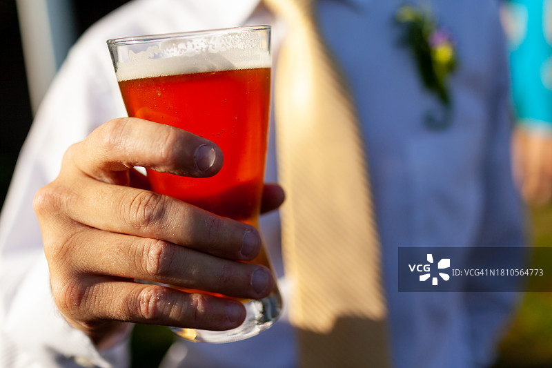 阳光下手持啤酒图片素材