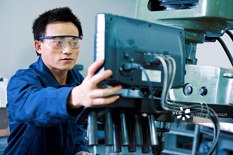 戴安全眼镜的男性铣床操作员图片素材