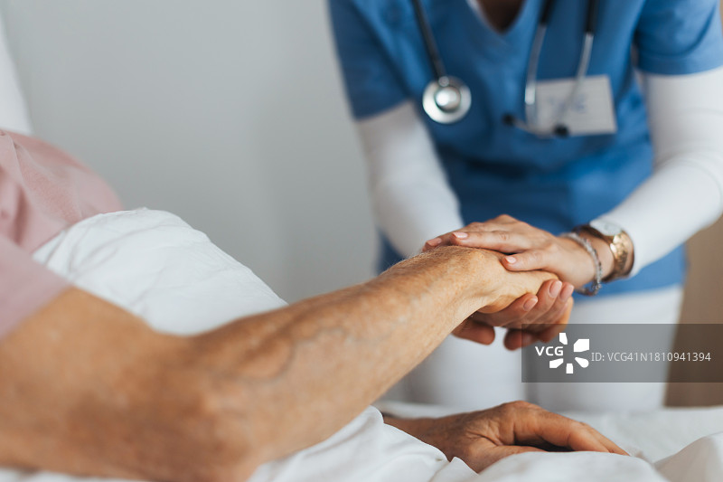 护理人员握着老年客户的手部特写图片素材