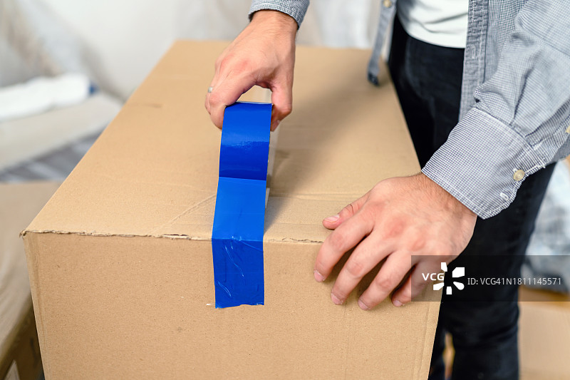 男人用胶带包装纸板箱图片素材