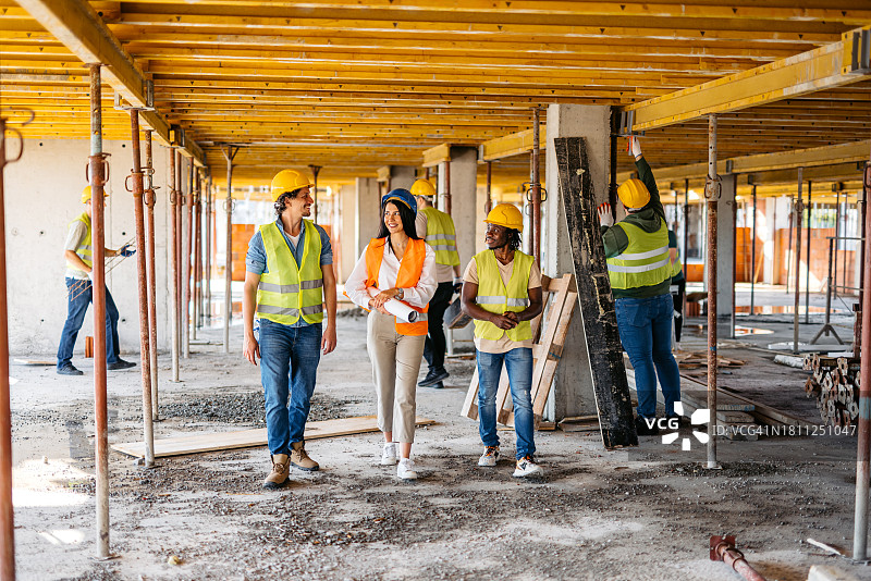 女工程师与建筑工人在施工现场巡视图片素材