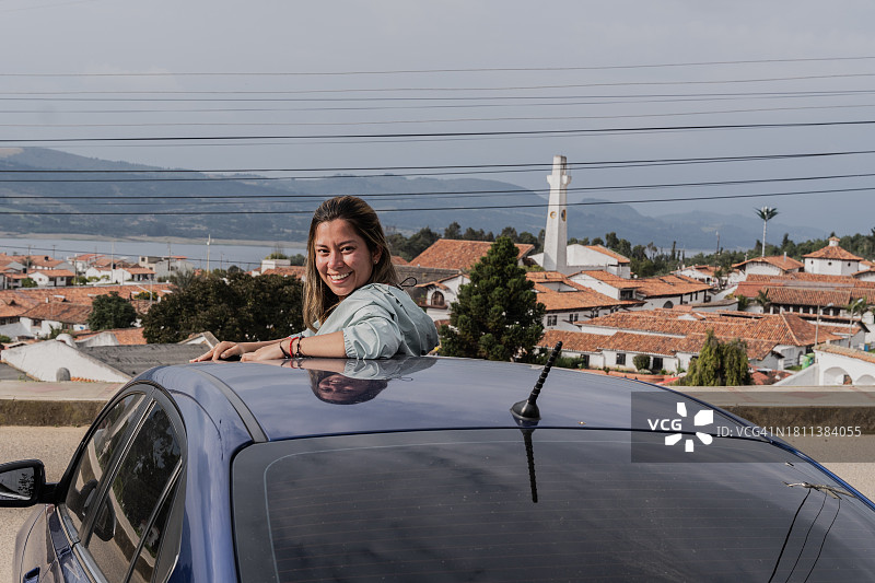 年轻女游客从汽车天窗探出身子的肖像图片素材