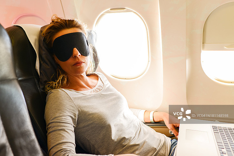 在飞机上小憩的中年妇女图片素材