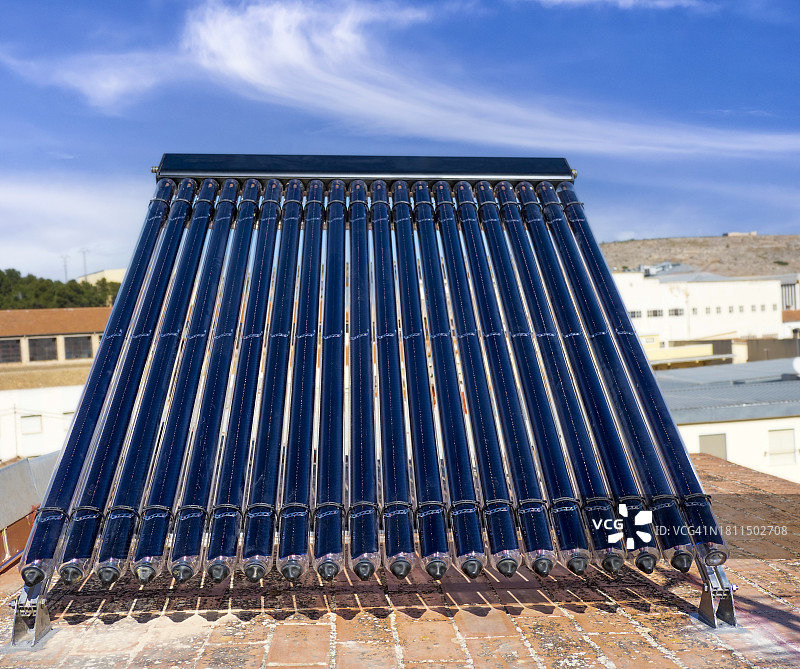 阳光照射下屋顶上的家用热水太阳能板图片素材