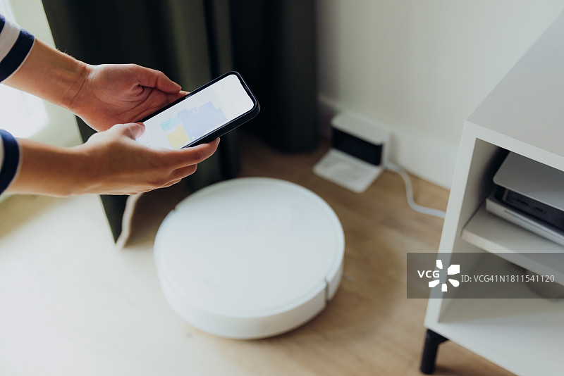 在现代厨房使用扫地机器人的女性特写图片素材