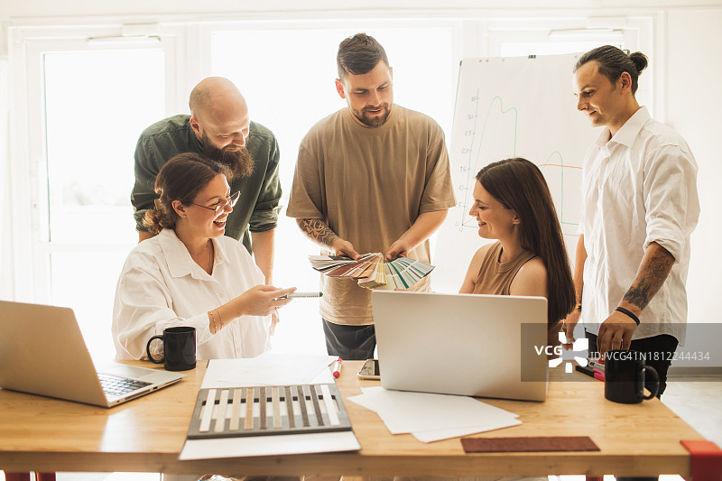 快乐的客户与设计师在店内办公室讨论房屋灰泥外观的材料样品细节图片素材
