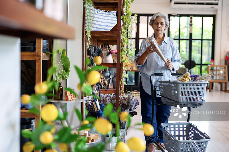 客户留存是小型企业成功的关键：亚裔妇女在装饰品店挑选人造花图片素材