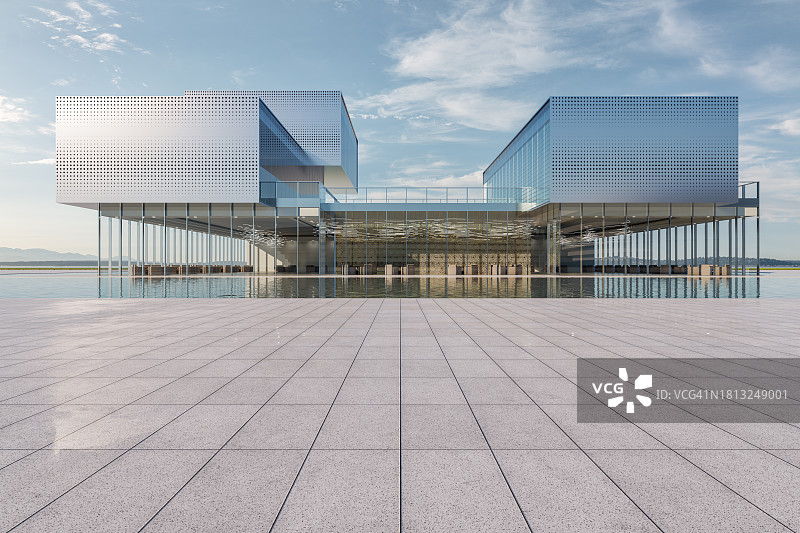现代建筑前方的空旷广场，带有银色金属面板和水池图片素材
