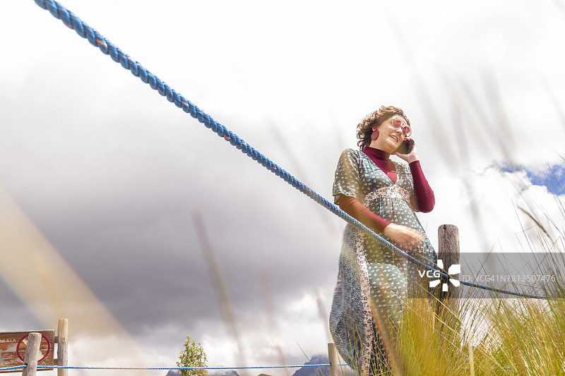 年轻女性独自旅行者在火山顶上用5G手机交谈图片素材