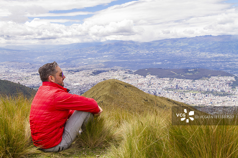 年轻男人独自旅行，在火山顶峰张开双臂的肖像图片素材