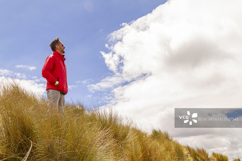 年轻男性背包客在钦博拉索火山顶徒步旅行，眺望厄瓜多尔首都基多图片素材