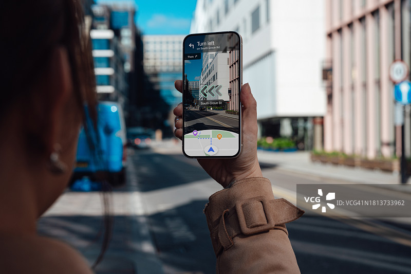 年轻女人在城市街道上使用AR导航图片素材