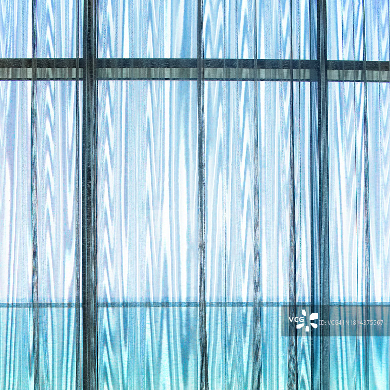 透过玻璃窗和薄纱窗帘看海滨图片素材