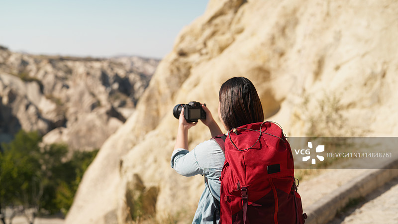 亚洲女游客在土耳其卡帕多奇亚用相机捕捉美景图片素材