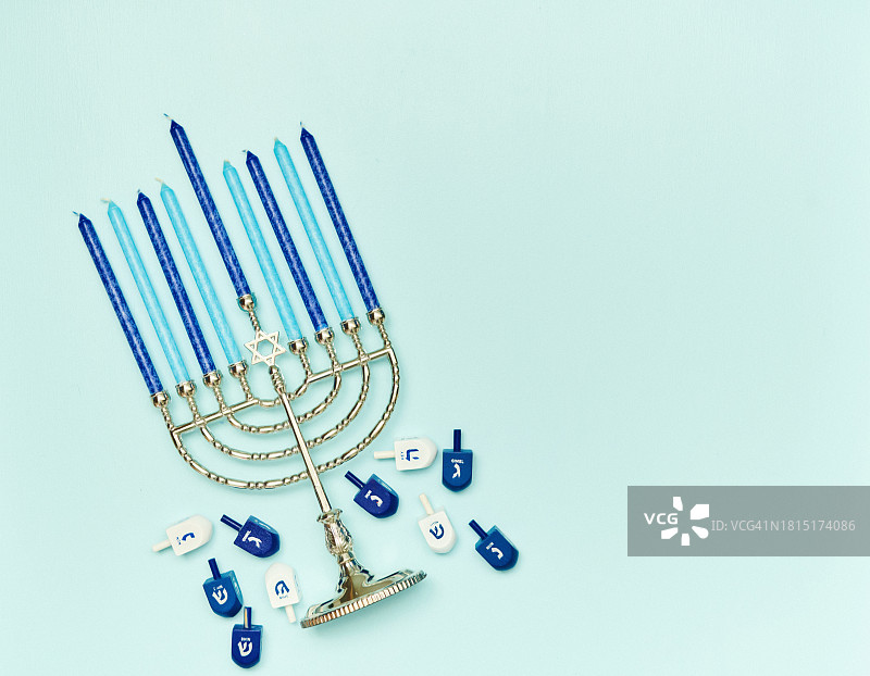 蓝色背景的光明节烛台和陀螺背景图片素材