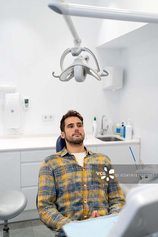 坐在牙科诊所里的严肃男人图片素材