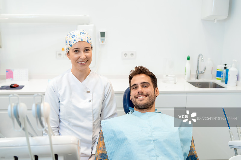 诊所里微笑的牙医和病人肖像图片素材