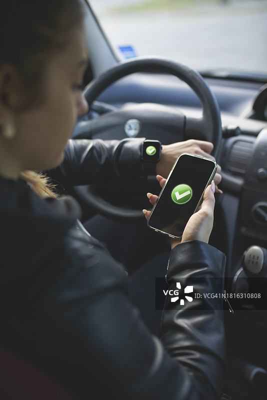 年轻女人在车内连接便携设备图片素材